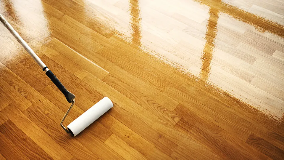 Trägolv behandlas med en roller.