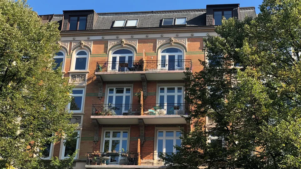 Wohnhaus mit Balkonen zwischen Bäumen in Hamburg-Winterhude