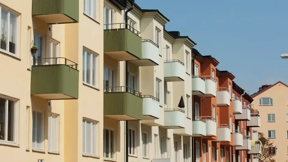 Rad av färgglada lägenhetshus med balkonger.