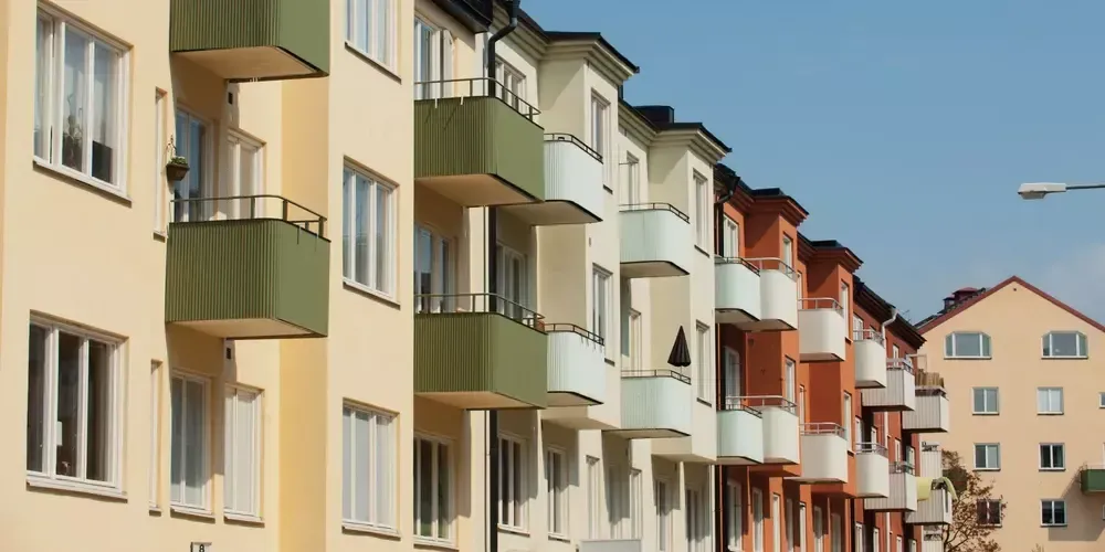 Rad av färgglada lägenhetshus med balkonger.