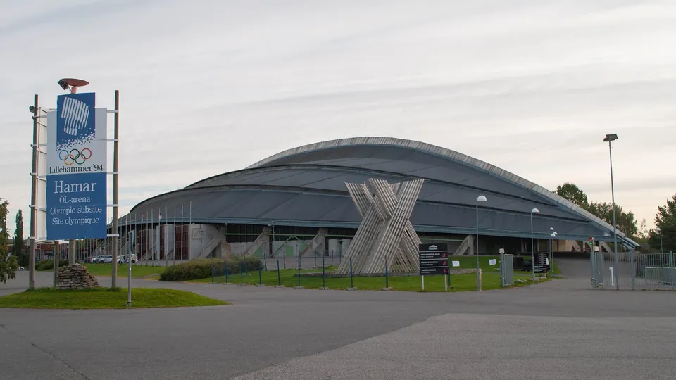 Hamar OL-arena, et olympisk anlegg med buet tak og skilt som viser Lillehammer '94 olympiske ringer.
