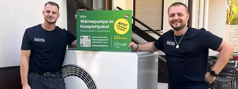 Zwei Installateure von Heizma bei einer installierten Luft-Wasser-Wärmepumpe.
