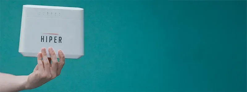 Billedet viser en hånd, der holder en Hiper-router