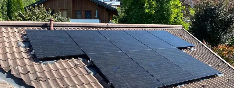 Hölzl Sonne GmbH – Photovoltaikanlage auf Ziegeldach vor alpiner Landschaft.