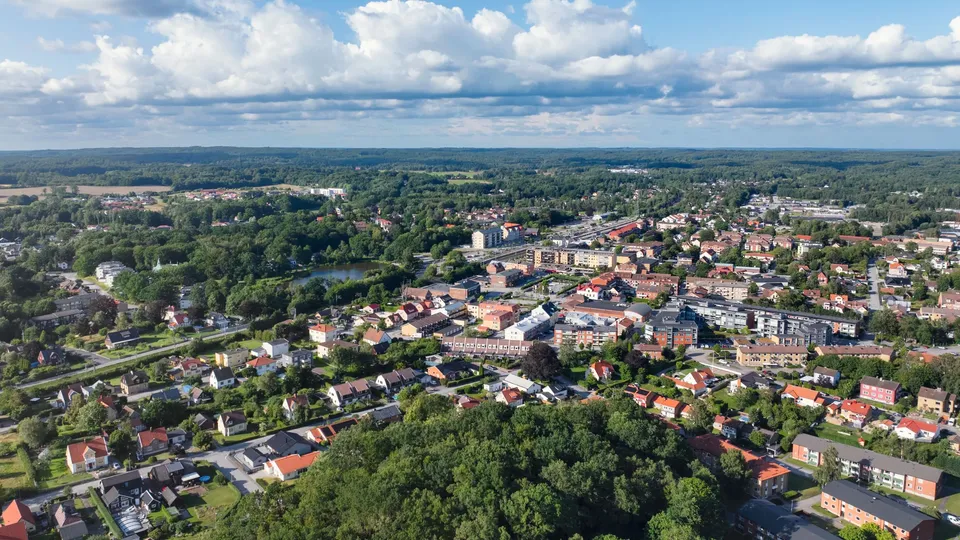 Ett stort bostadsområde som är omgivet av skog, med en liten sjö i mitten.