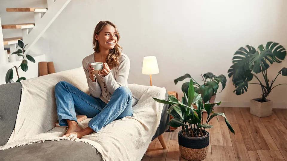 Kvinde sidder hjemme med en kop kaffe