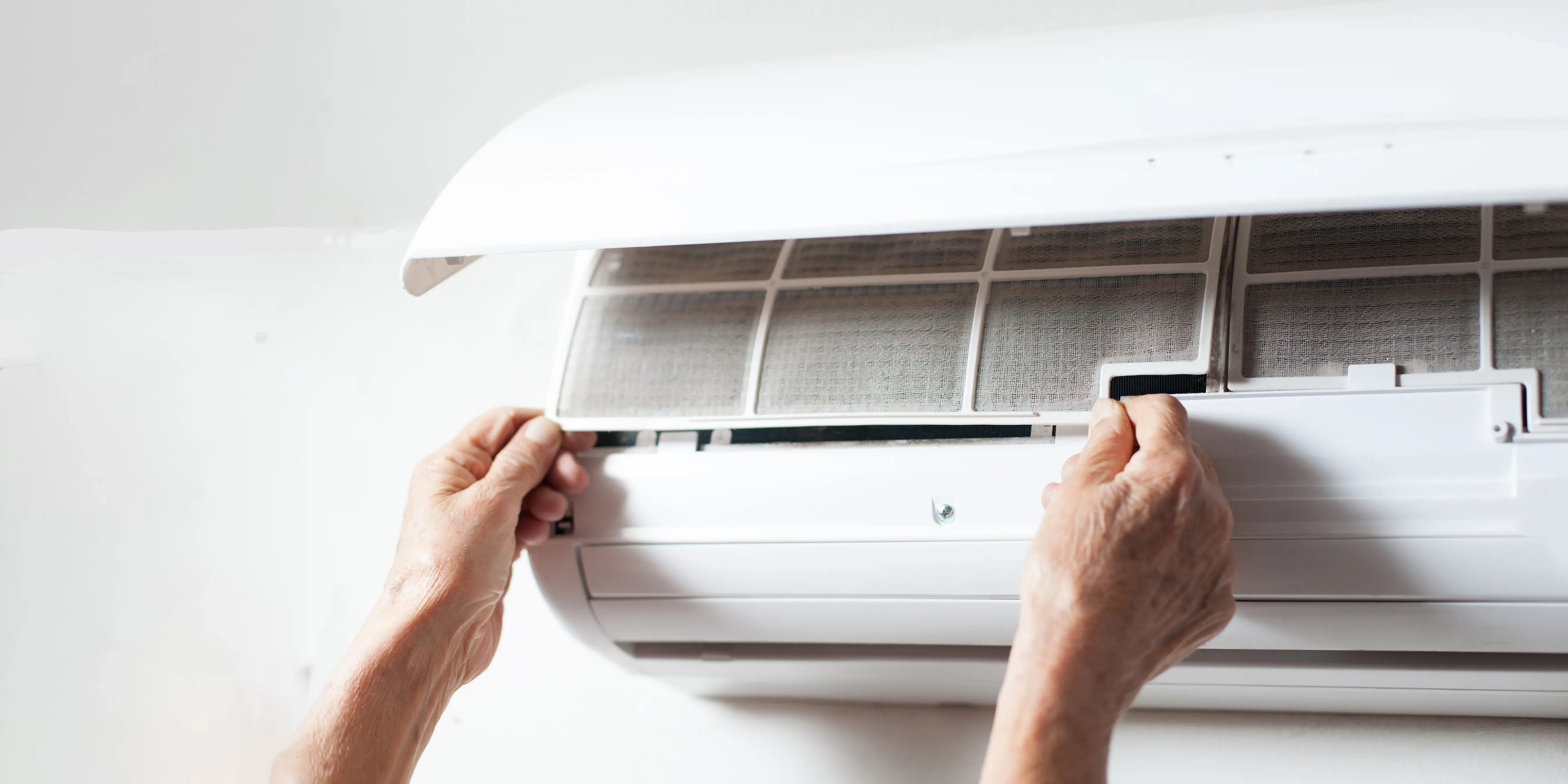 Person fjerner filterplate fra varmepumpe