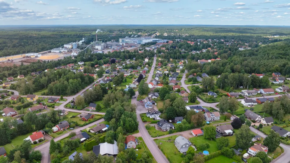 Utsikt över ett grönskande bostadsområde, med ett industriområde som skymtar längst bort.