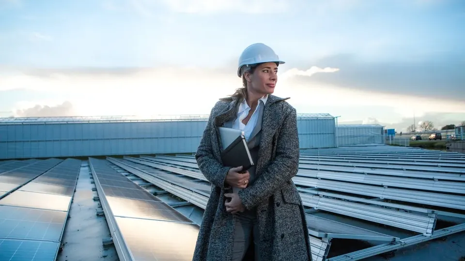 Une femme ingénieure devant l'installation solaire d'une entreprise