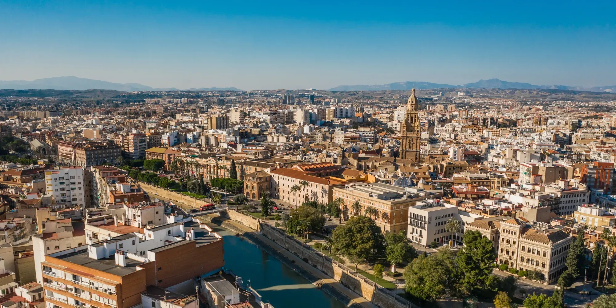 Vista aérea del paisaje urbano de Murcia con catedral y río.