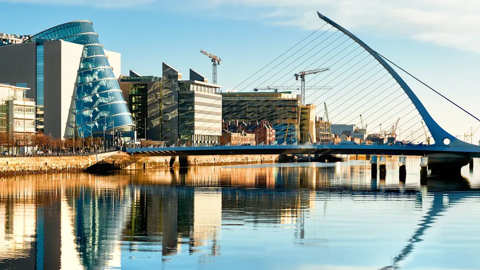 Samuel Beckett Bridge and modern buildings reflecting on the River Liffey in Dublin