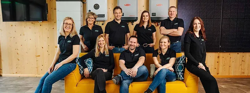 EET Knees GmbH & Co. KG – Teamfoto vor Wechselrichtern für Photovoltaikanlagen im Firmenshowroom.