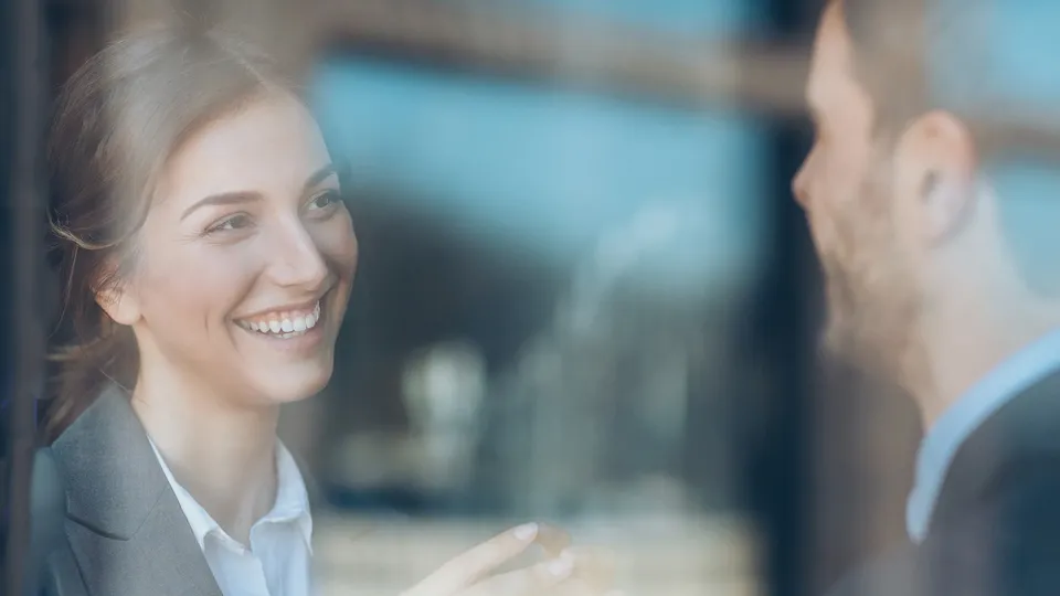 A woman and a man in business attire having a conversation.