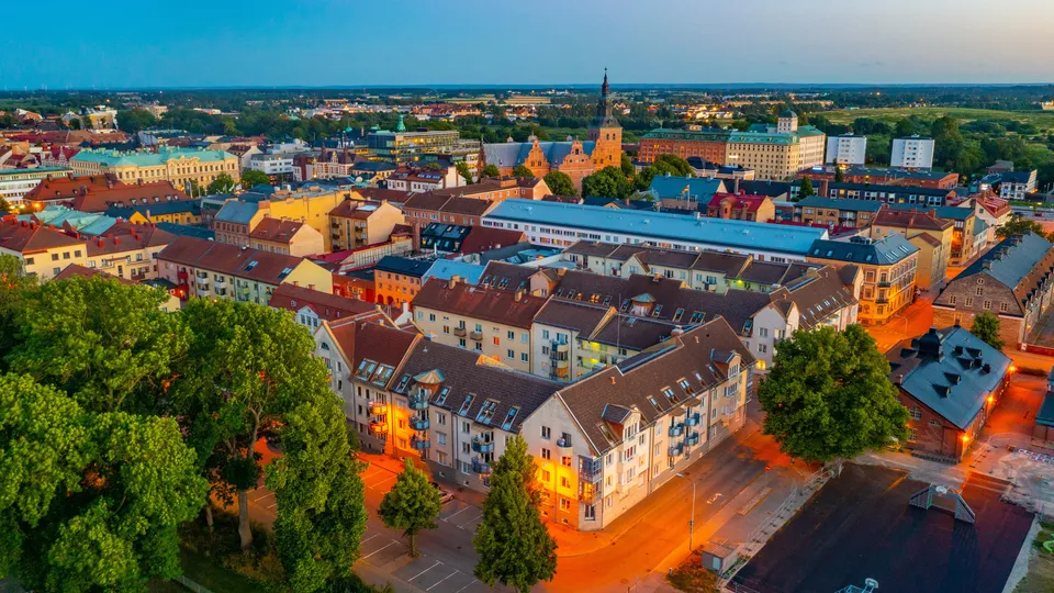 Flygfoto över Kristianstad med färgglada byggnader och kyrktorn.