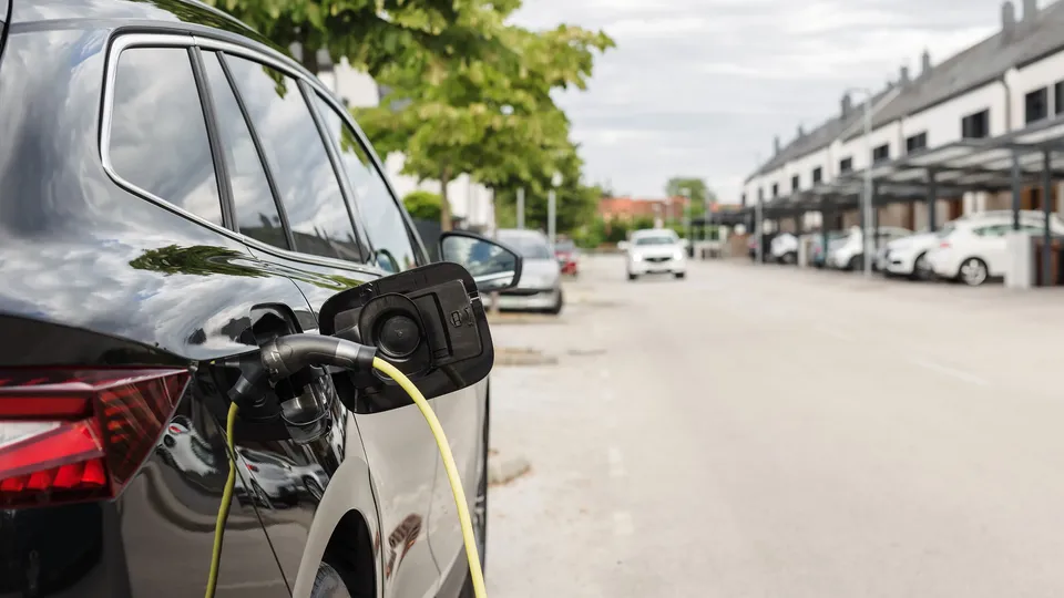 Elektrisk køretøj oplades ved ladestation.