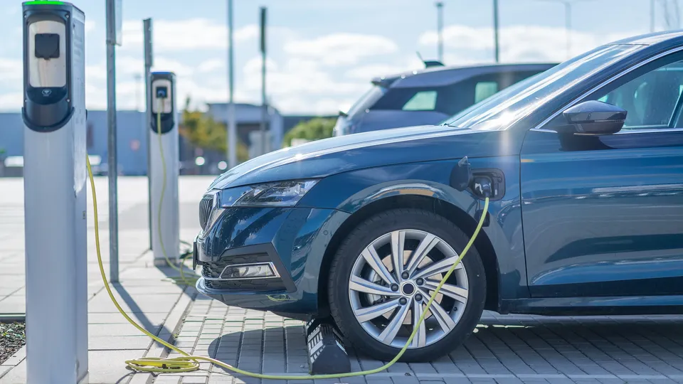 Blå elektrisk bil oplades ved virksomheds ladestation.