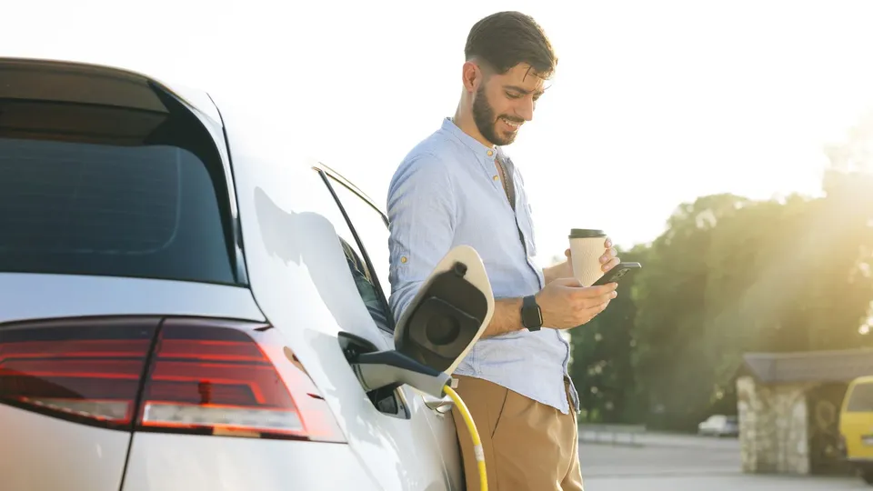 A person enjoying a coffee while they charge their EV.