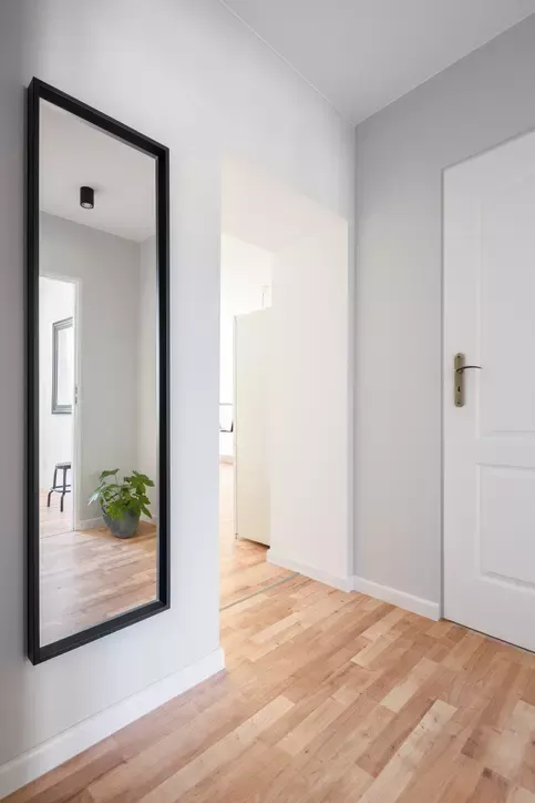 Korridor med spegel i full längd som reflekterar inredningen.