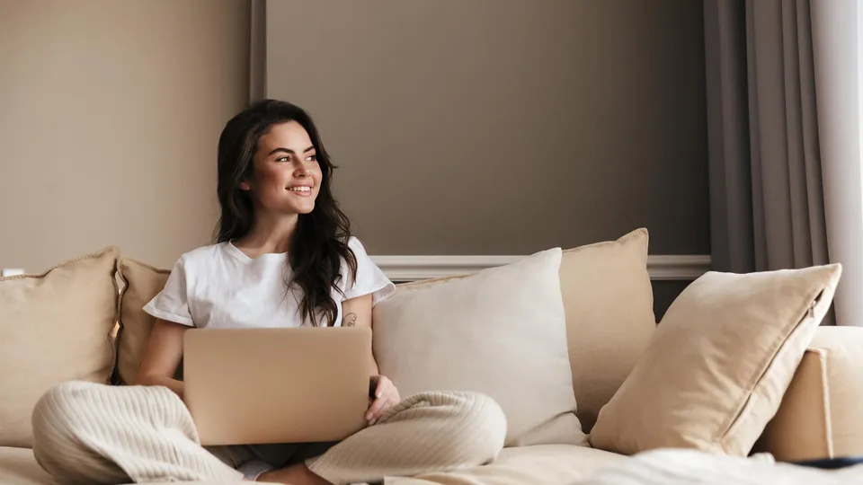 Kvinde sidder hjemme med sin computer