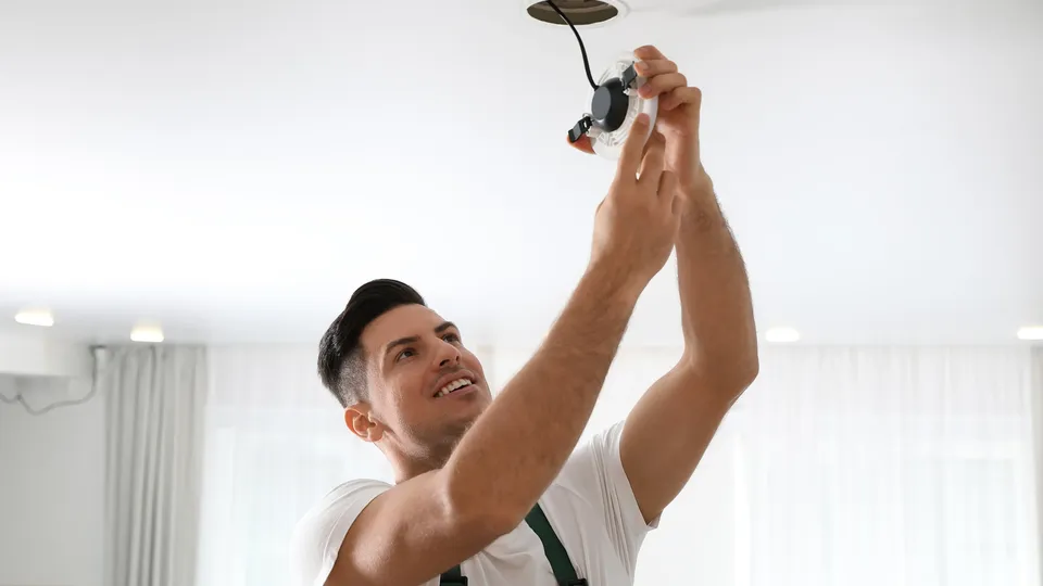 Mann installerer innfelt taklampe.