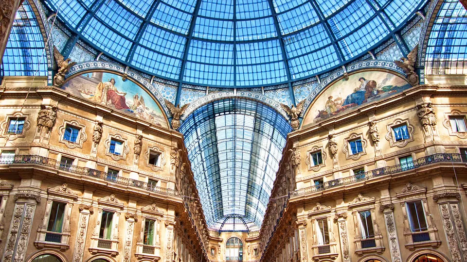 Interno di galleria ornato con volta a botte in vetro e facciate in pietra decorata.