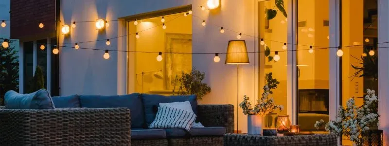 Terrasse med en masse tændte lys og lyskæder. Indhent tilbud på en elaftale, og se om du kan spare penge på din elregning.