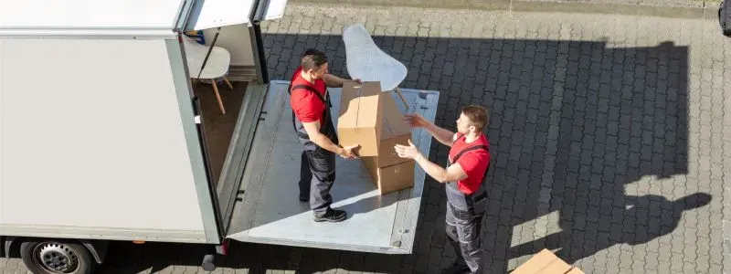 Flyttemænd pakker en flyttevogn.