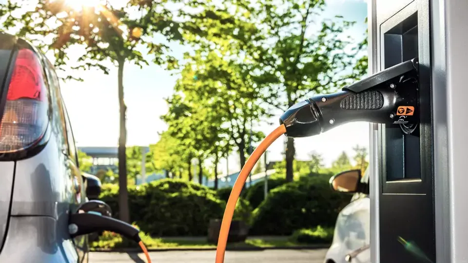 Elektrisk køretøj opladningskabel tilsluttet vægmonteret ladestation.