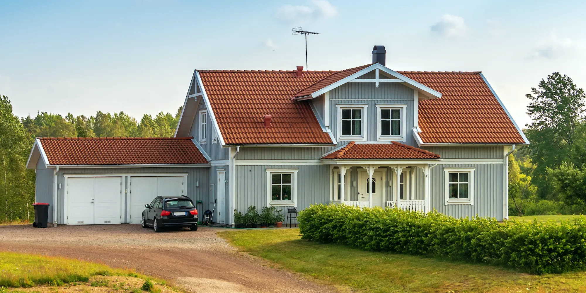 Moderne toetasjes hus med rødt takstein og tilknyttet garasje.