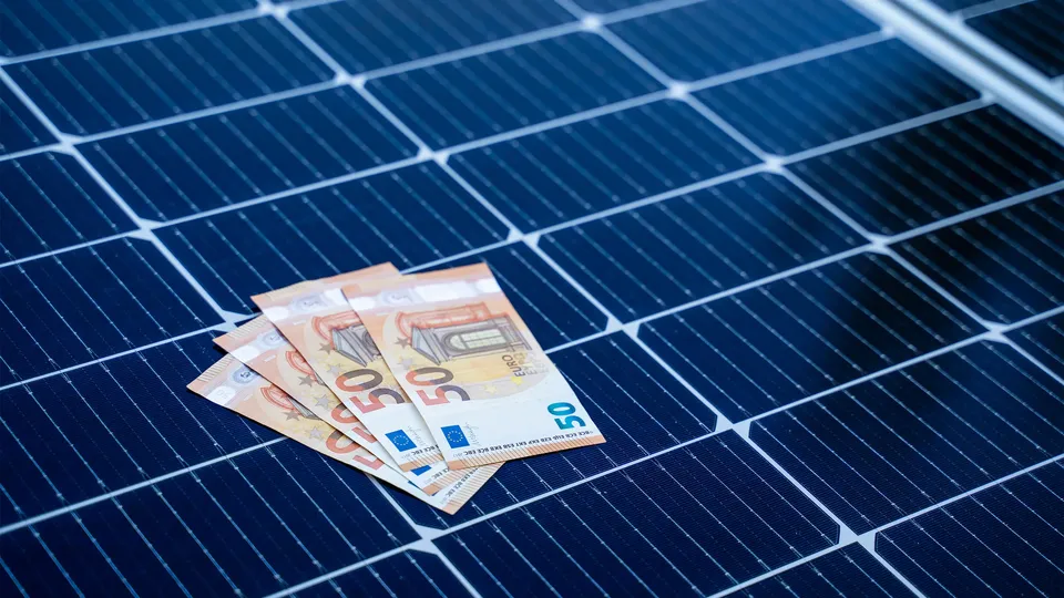Mehrere 50-Euro-Scheine liegen auf einem Solarmodul.