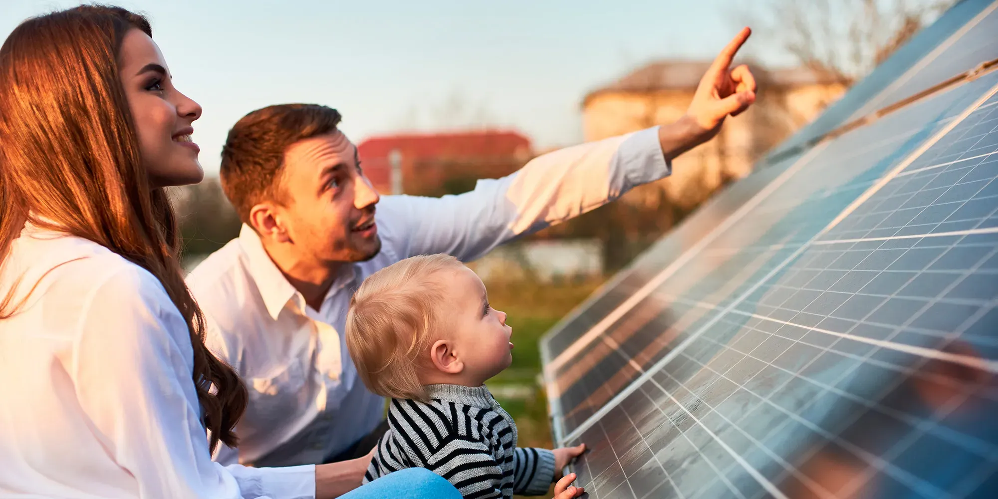 Familia observando paneles solares en un tejado.