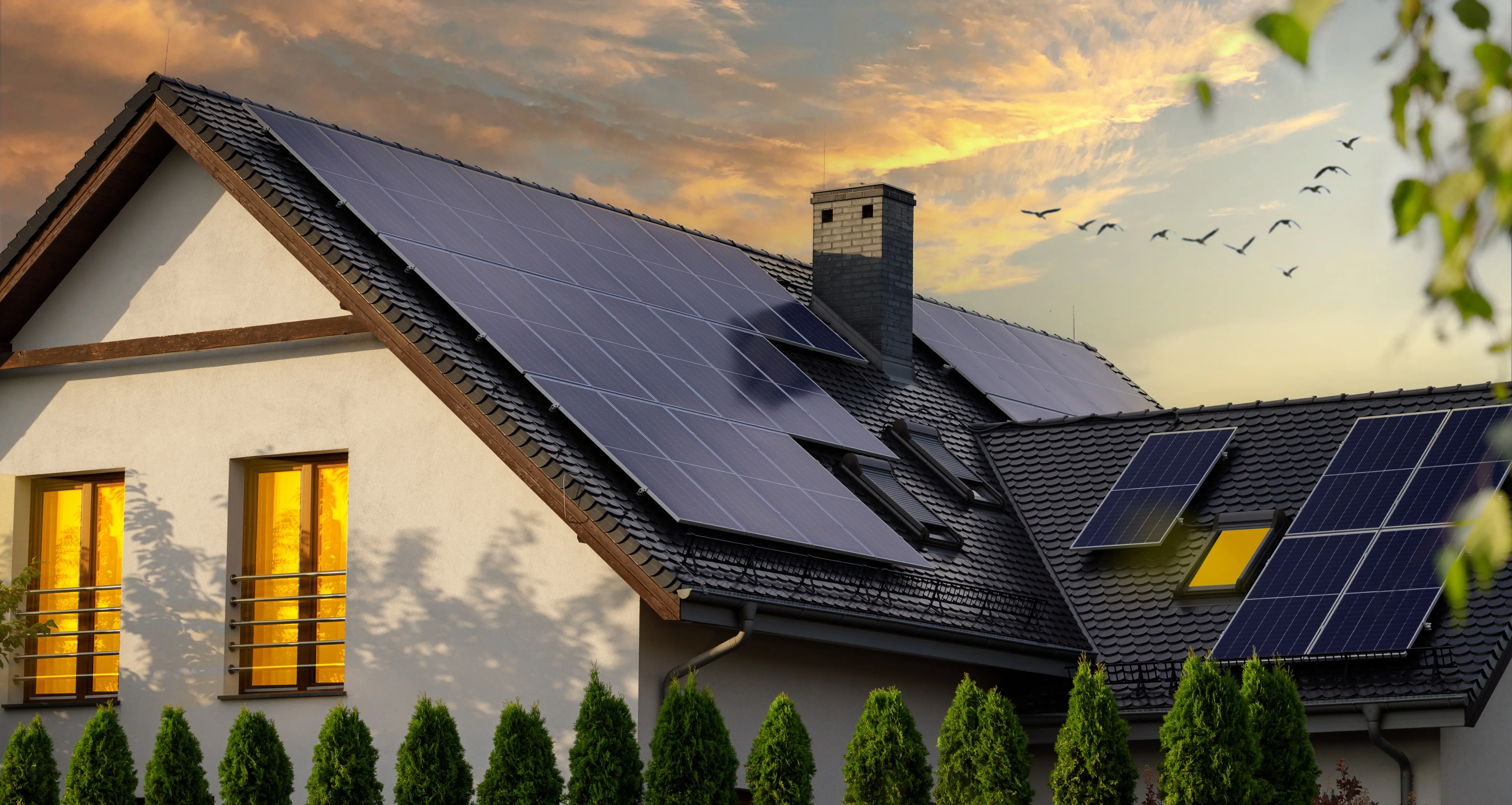 Casa moderna con paneles solares en el techo al atardecer.
