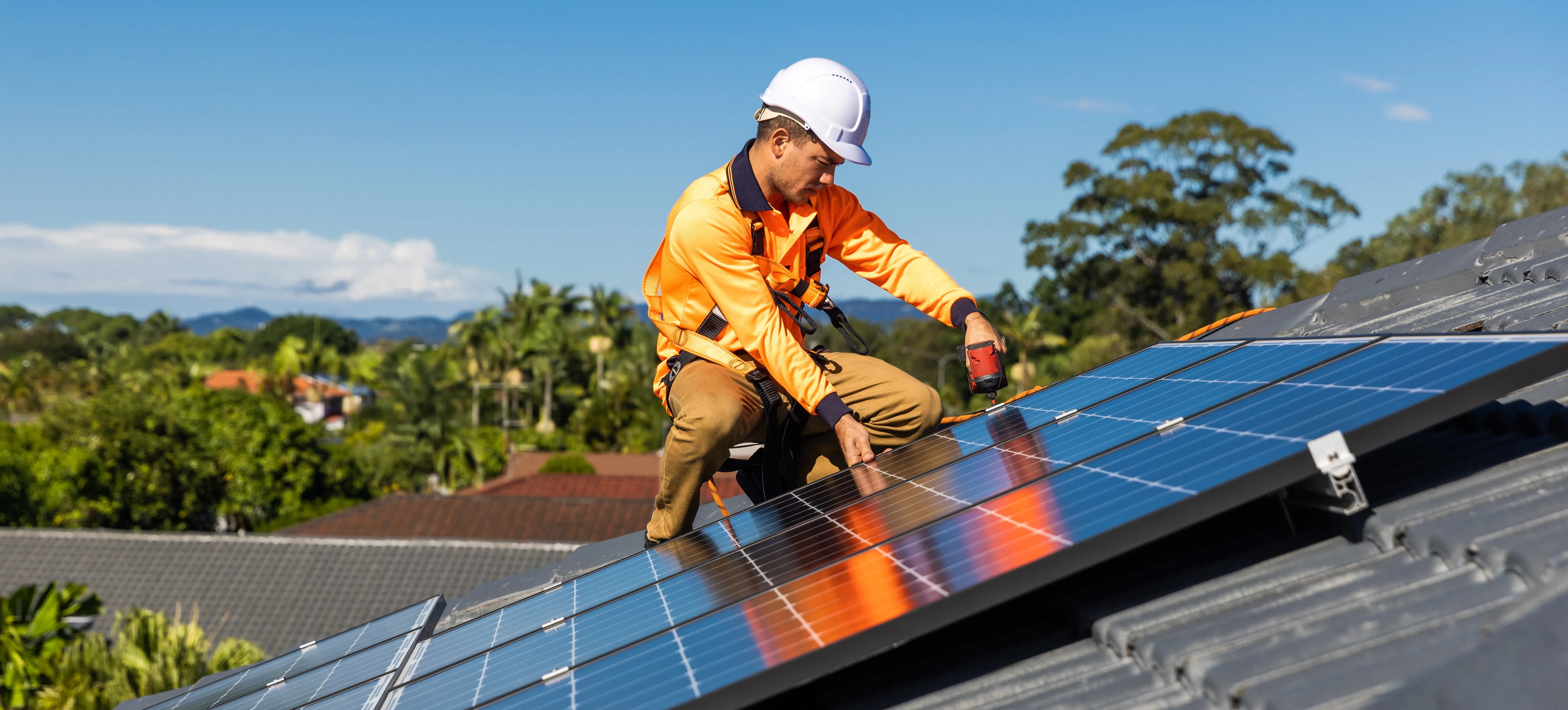 Instalador de paneles solares trabajando en paneles solares en tejado.