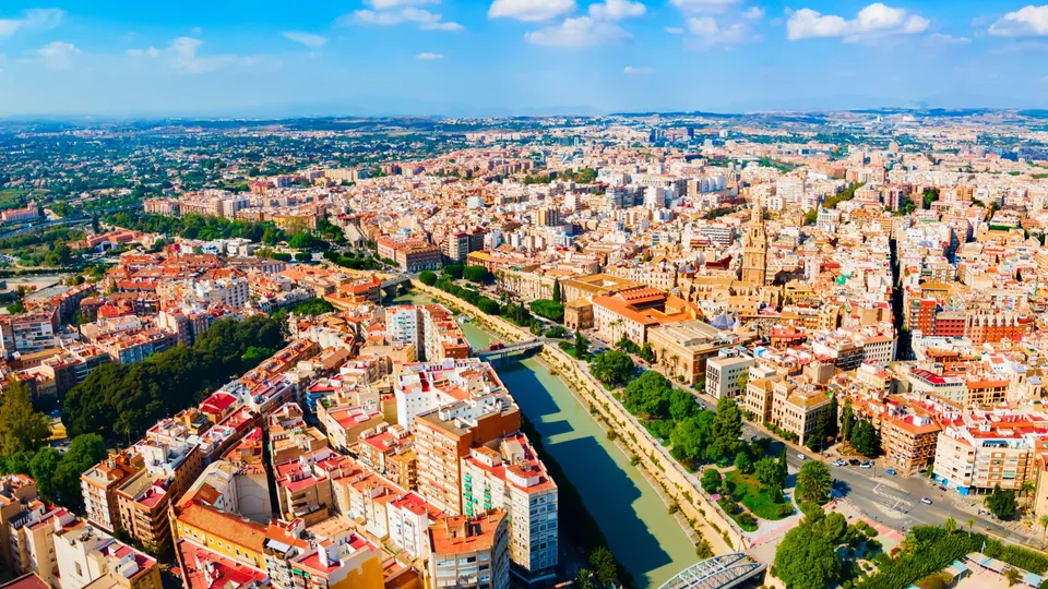 Vista aérea de una ciudad española con un río atravesándola y el campo circundante.