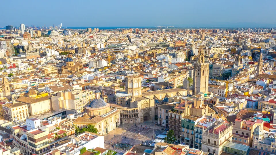 Vista aérea del paisaje urbano de Valencia con torres de catedral e iglesia en primer plano.