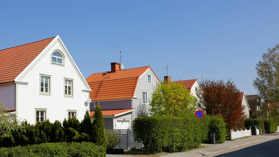 Rad av ljusa villor med röda tegeltak i ett typiskt svenskt villakvarter.
