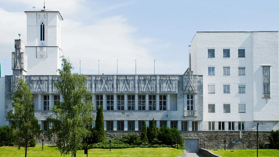 Hvit art deco-kommunebygning med tårn og ornamentert fasade.
