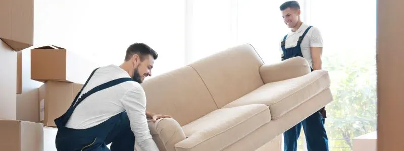 Flyttemænd bærer en sofa.