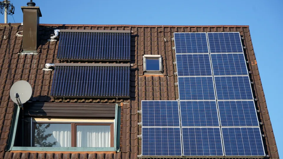 Dach mit installierten Solarpanelen und Thermalkollektoren.