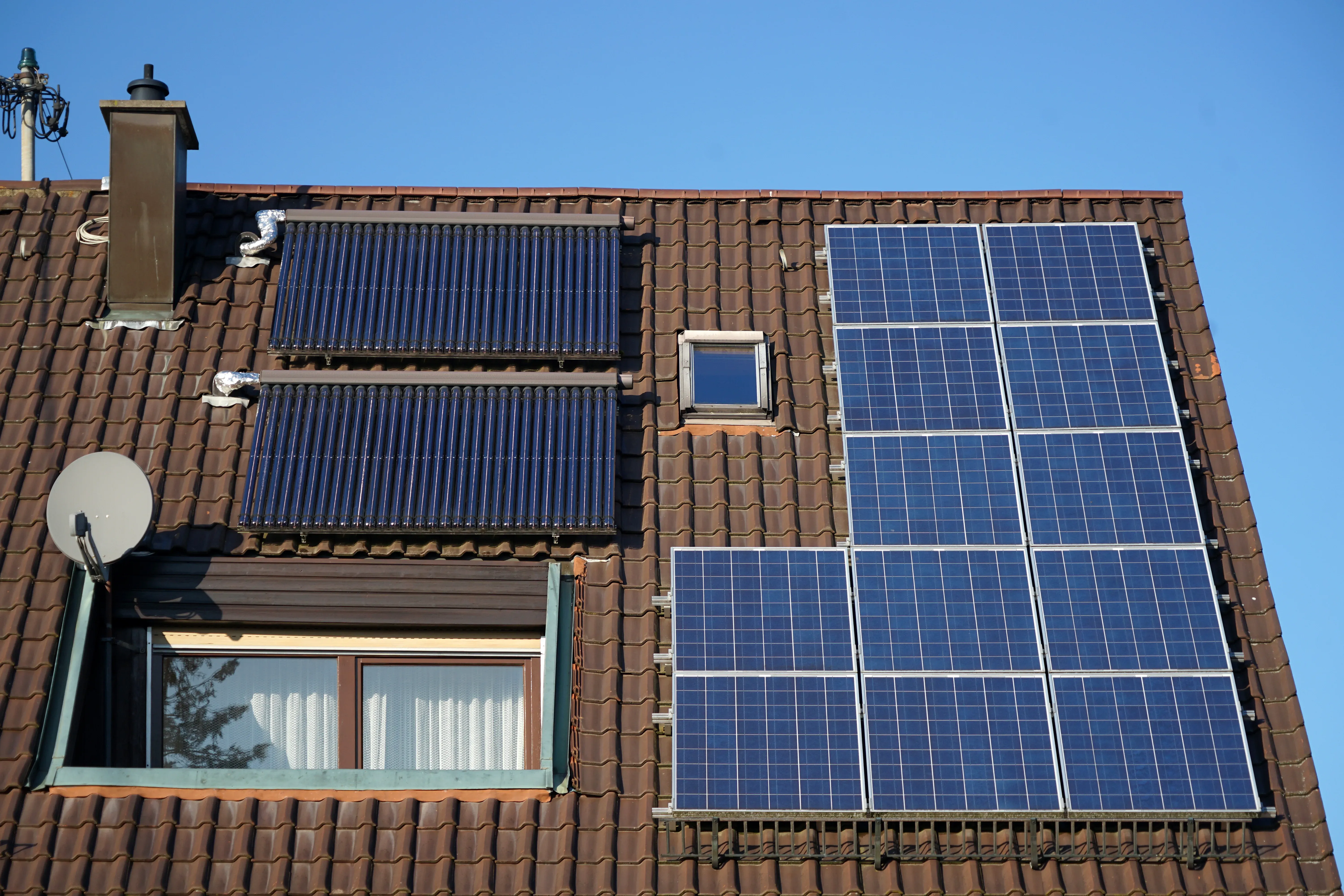Dach mit installierten Solarpanelen und Thermalkollektoren.