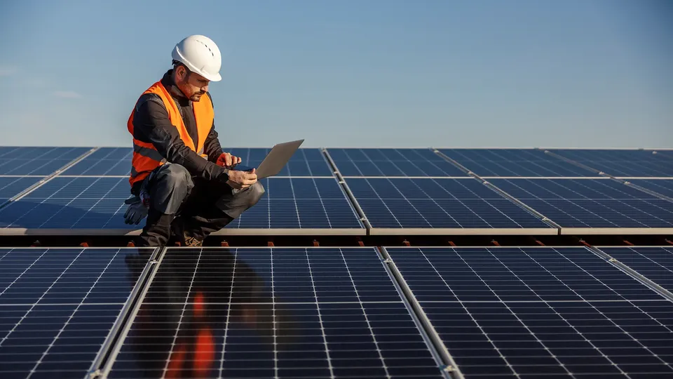 Solar installer checking solar panels that he has just installed