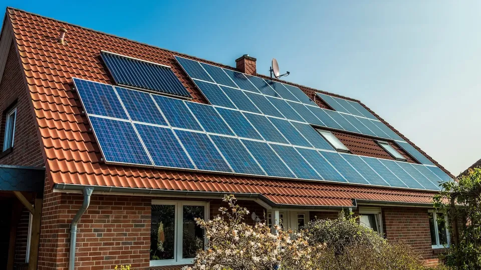 Casa in mattoni residenziale con pannelli solari installati su tetto in coppi.