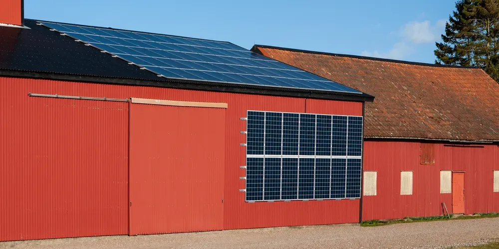 Röd ekonomibyggnad med solceller på tak och vägg.