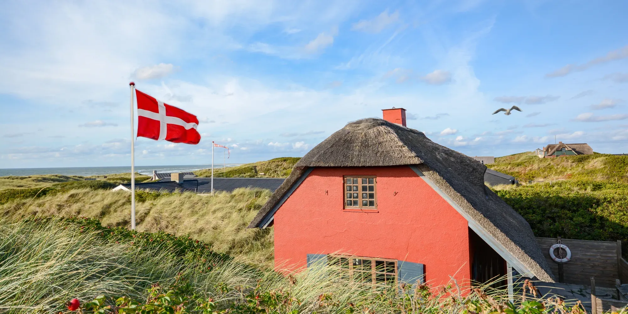 Rødt sommerhus på den danske vestkyst