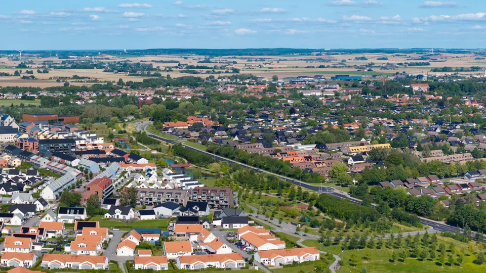 Vy över ett villaområde med hus och en väg.