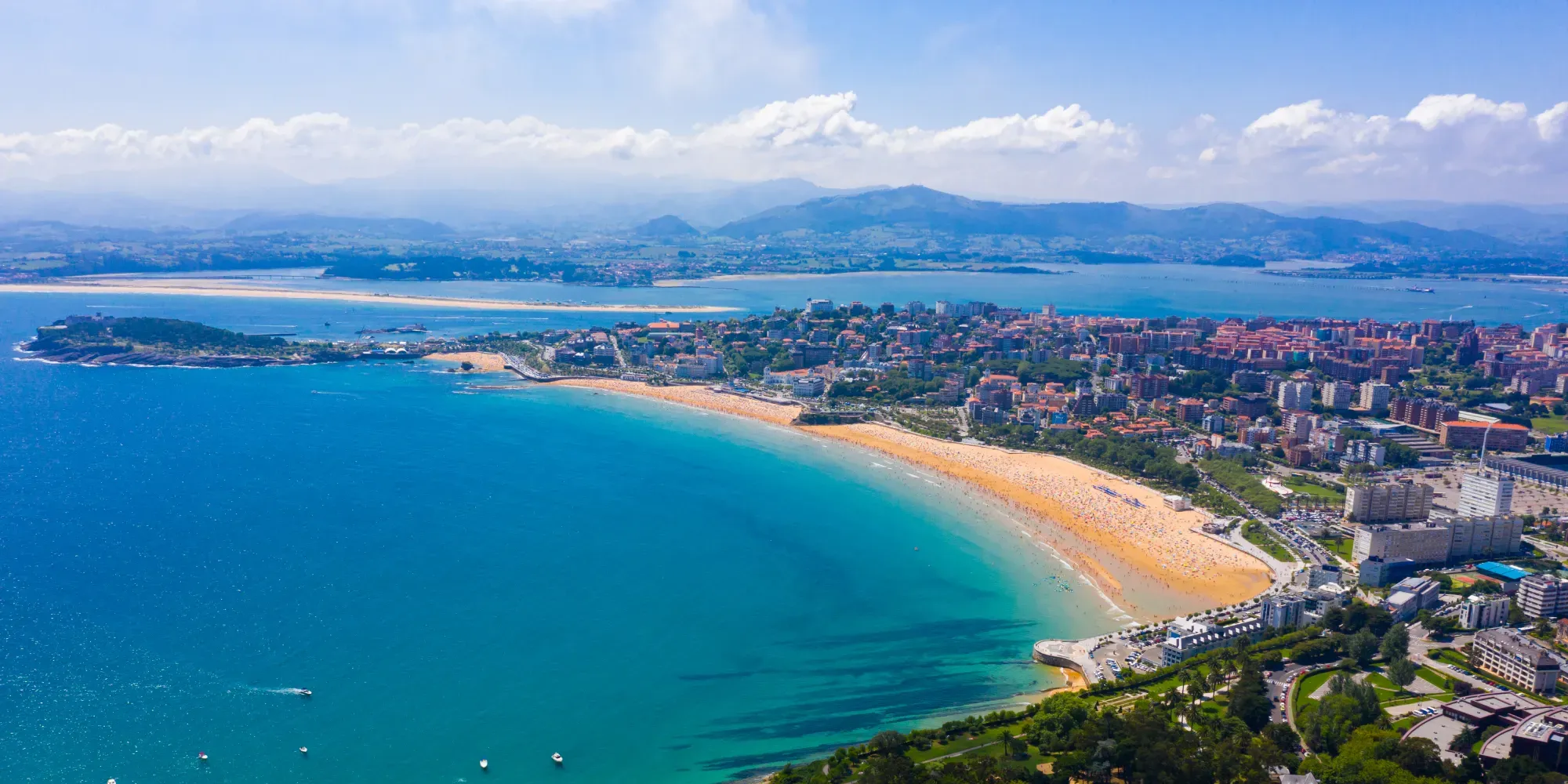 Vista aérea de la playa de Santander y la ciudad costera con agua turquesa.