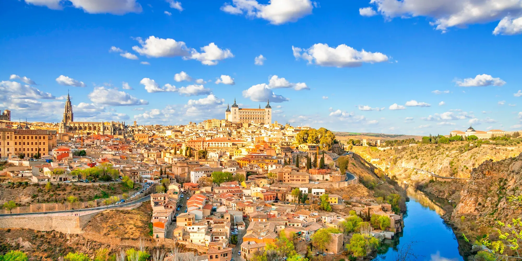 Ciudad histórica en colina con catedral y castillo sobre garganta fluvial.