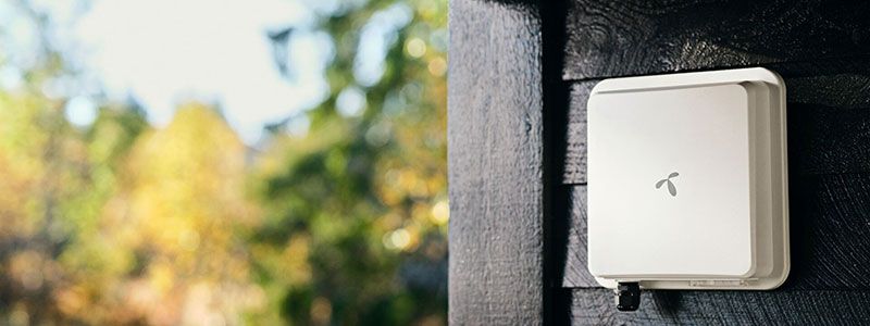 Nærbilde av en veggmontert utendørsantenne for trådløst bredbånd med telenor logoen på.