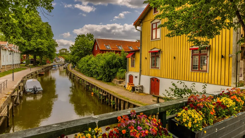 Ett gult hus vid en kanal där en liten båt har lagt till.
