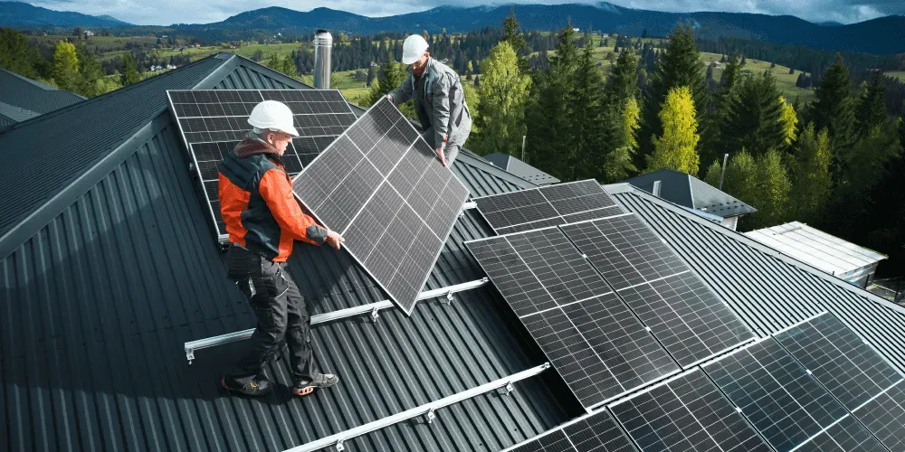 Two workers installing solar panels on a metal roof - Monocrystalline, Polycrystalline and Thin-film